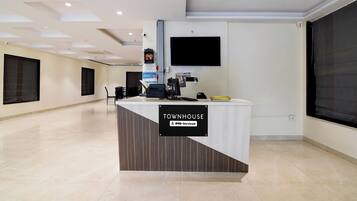A reception desk labeled 'TOWNHOUSE' with a sign indicating 'OOO-Serviced.'