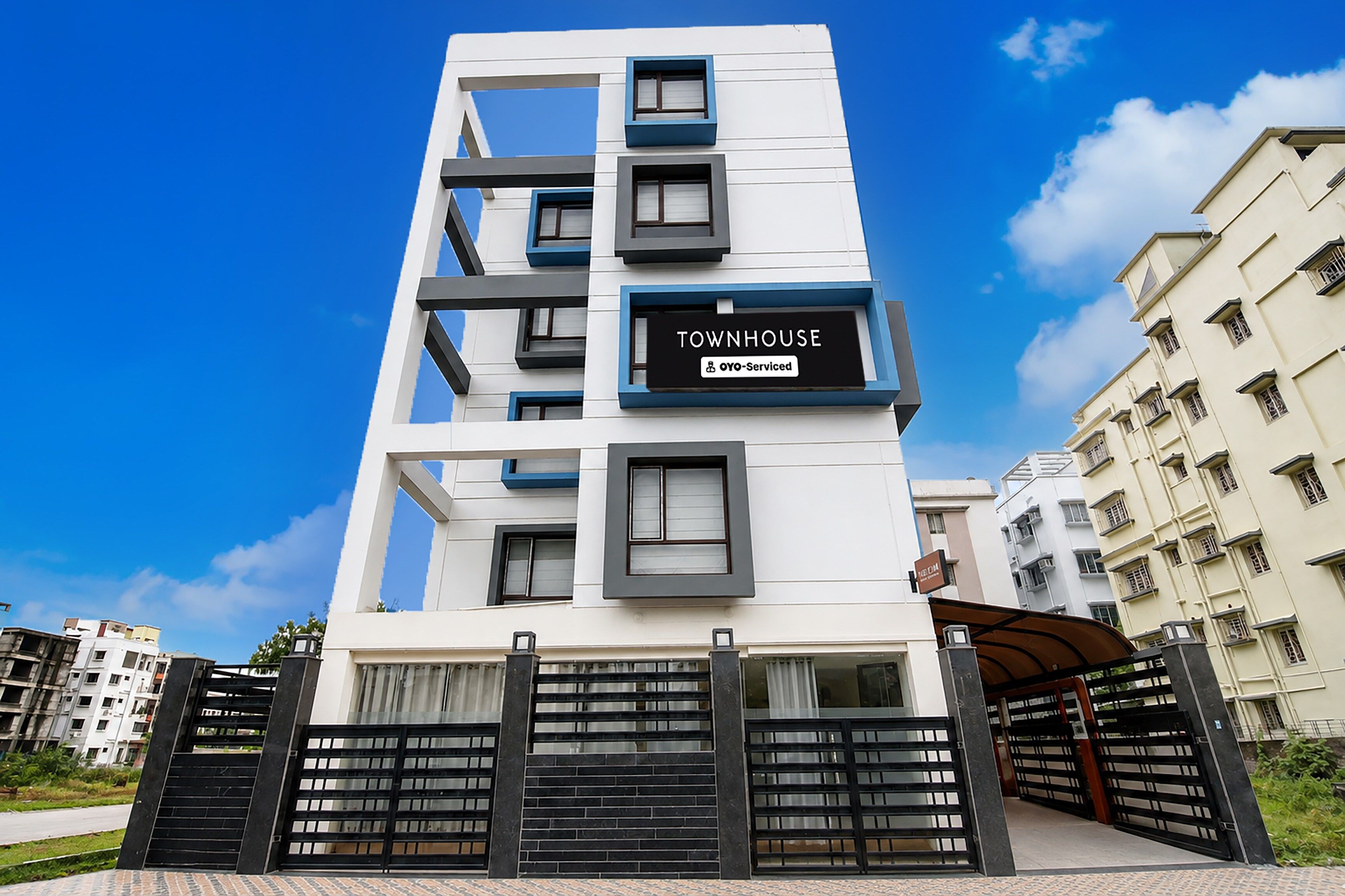 A modern townhouse with a sign indicating it is serviced by OYO.