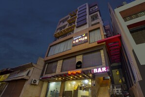 Un edifici de diverses plantes amb un rètol que diu 'Hotel Lotus' i un 'Restaurant Bar' a la planta baixa.