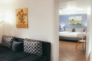 A room with a bed, a sofa, and a painting on the wall. - House Luna - Apartment Luna 1 (Schwangau)