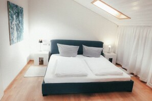 Ein Schlafzimmer mit einem Bett, Nachttischen und einem Bild an der Wand.
