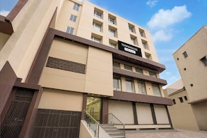 A multi-story building with a sign reading 'TOWNHOUSE' and 'Oyo-Serviced' indicating serviced apartments. - Townhouse Oak Central Bus Station Rajkot (Rajkot)