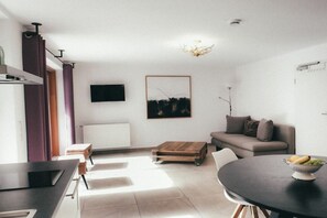 A modern living room with a sofa, a coffee table, and a dining table. - House Luna - Apartment Luna 5 (Schwangau)