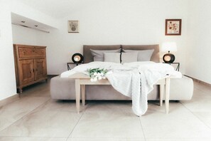 A bedroom with a bed, bedside tables, a wooden cabinet, and wall art. - House Luna - Apartment Luna 8 (Schwangau)