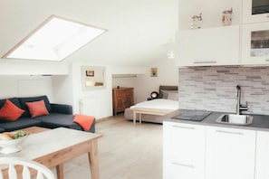 A modern apartment with a dining area, kitchenette, and a living space with a sofa and ottoman. - House Luna - Apartment Luna 8 (Schwangau)