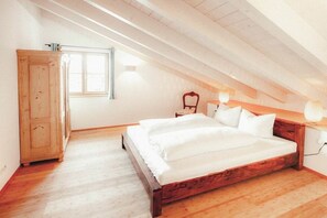 Une chambre à coucher avec un lit en bois, une armoire et une fenêtre.