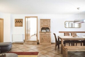 Ein Essbereich mit einem Holztisch, Stühlen, einem Heizkörper und einem Spiegel an der Wand.