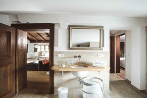 A bathroom with a wooden vanity, a large mirror, and a sink. - Luna Mia Apartment 4 (Schwangau)