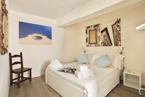 A hotel room with a bed, a chair, a bedside table, and artwork on the walls. - Holiday Home 'Alex's House Signoria' with Wi-Fi (Firenze)