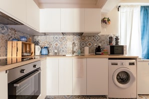 A modern kitchen with a washing machine, a microwave, and a sink. - Holiday Home 'Anna's House Ponte Vecchio' with Wi-Fi (Firenze)