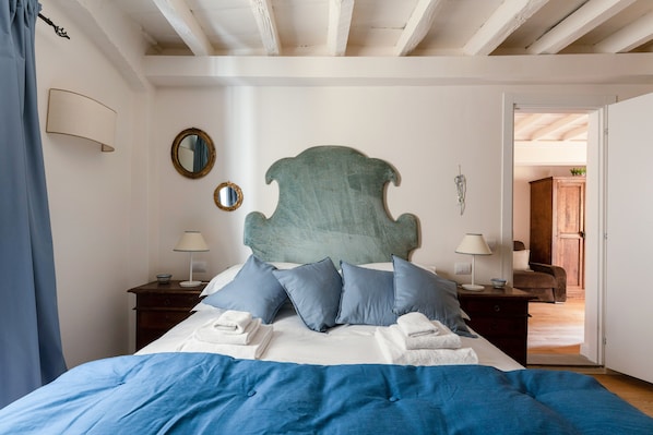 A bedroom with a bed, two bedside tables, a mirror, and a door leading to another room. - Holiday Home 'Anna's House Ponte Vecchio' with Wi-Fi (Firenze)