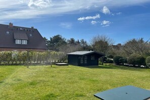 A residential property with a large house, a smaller shed, and a well-maintained lawn. - Holiday apartment in Sylt with swimming pool (Sylt)