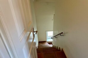 A staircase with a handrail, a door on the left, and a window at the top. - Holiday apartment in Sylt with swimming pool (Sylt)