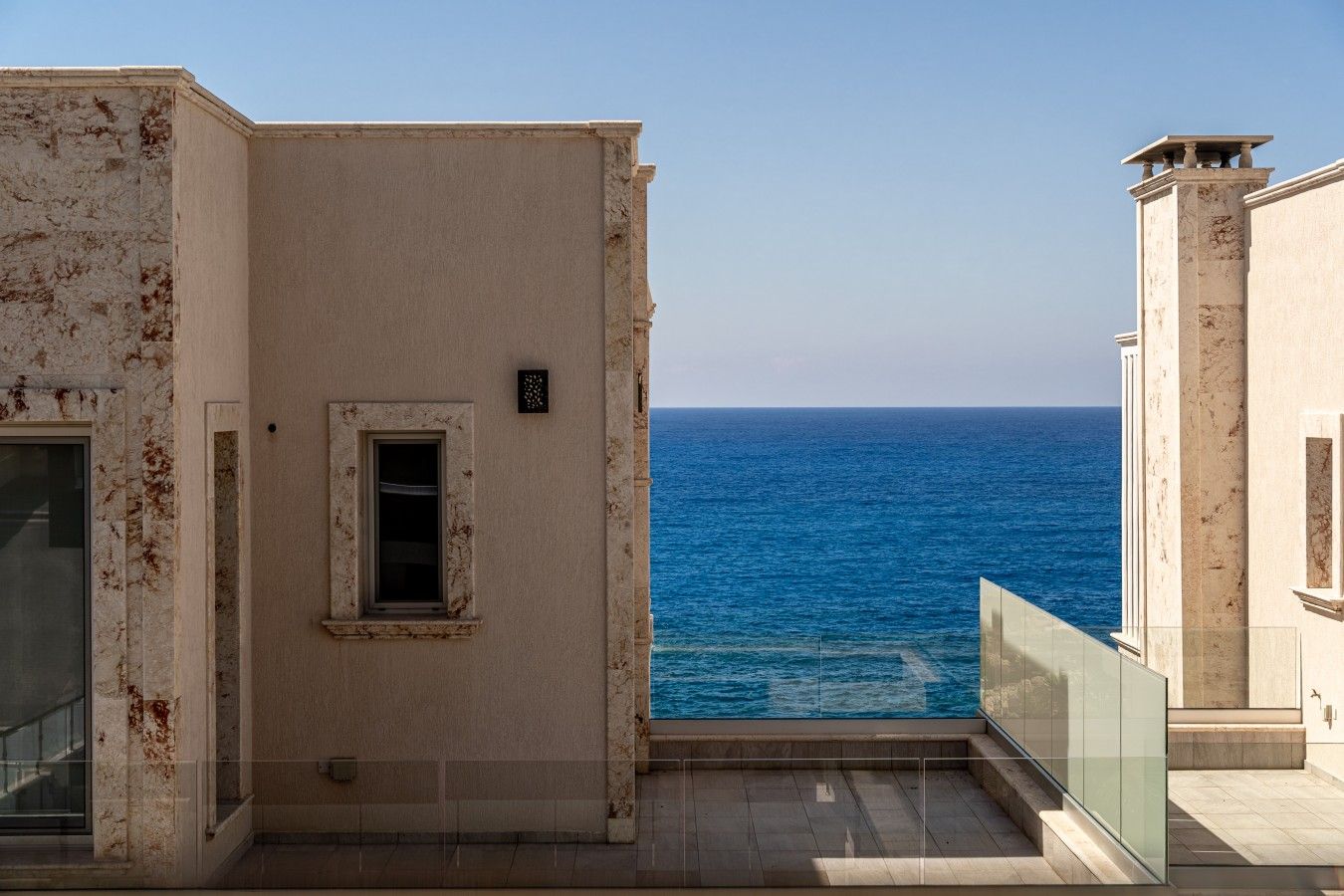 Un edificio con vista al mar, una ventana pequeña y un balcón.