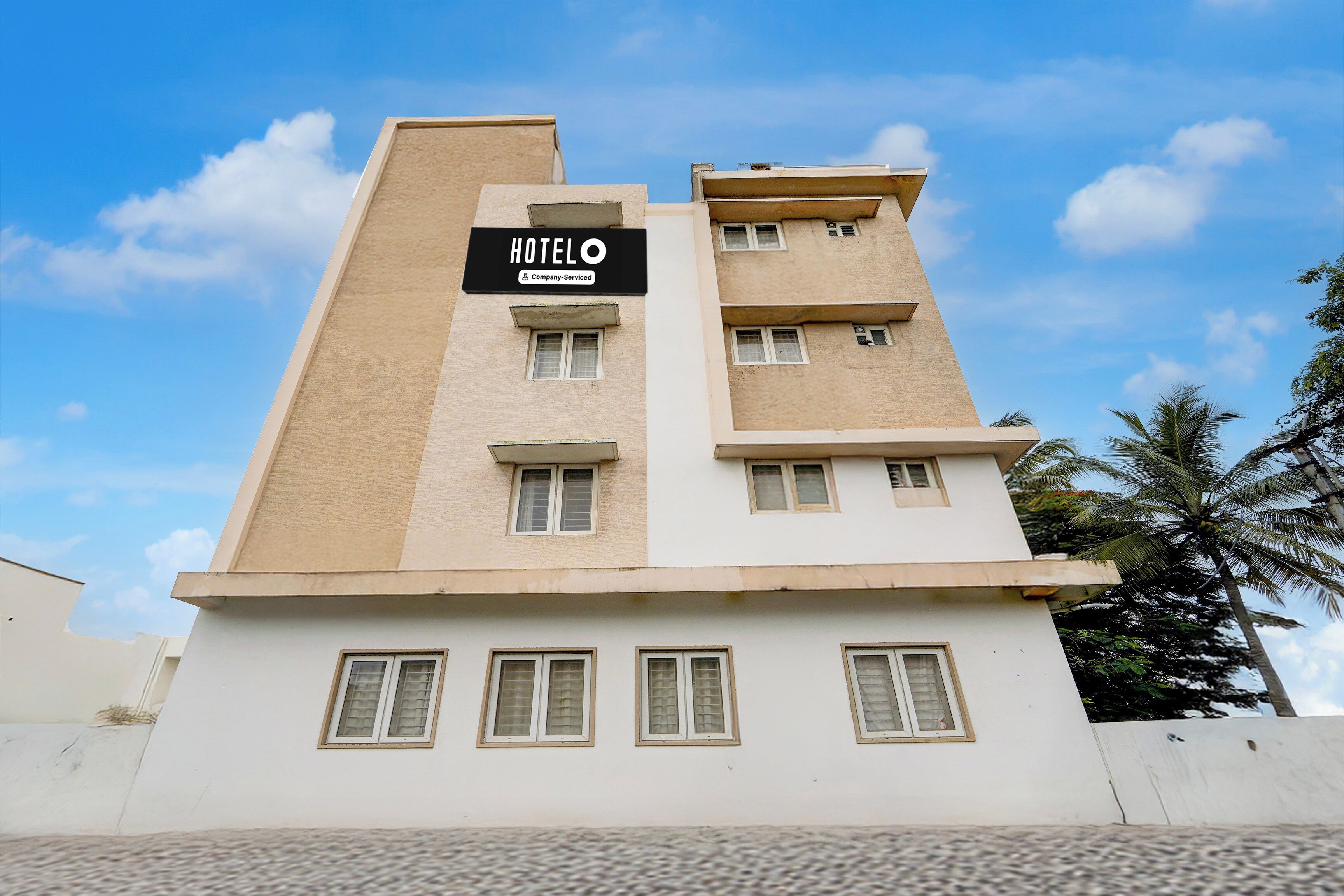 A multi-story hotel building with a sign indicating it is a company-serviced hotel.