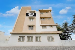 Un edificio de hotel de varios pisos con un cartel que indica que es un hotel de servicios para empresas.