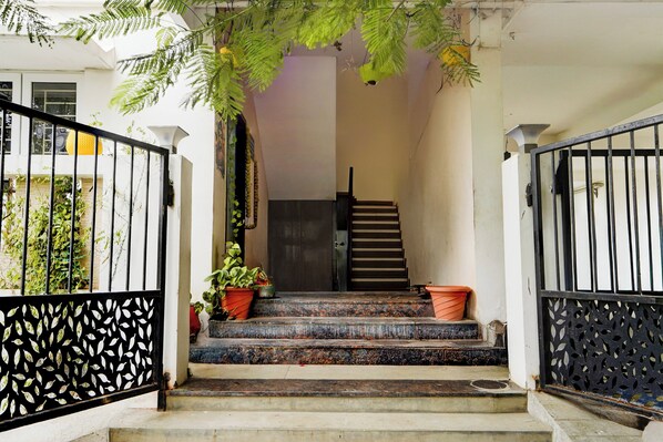Una escalera que lleva a una puerta con una reja metálica a cada lado.