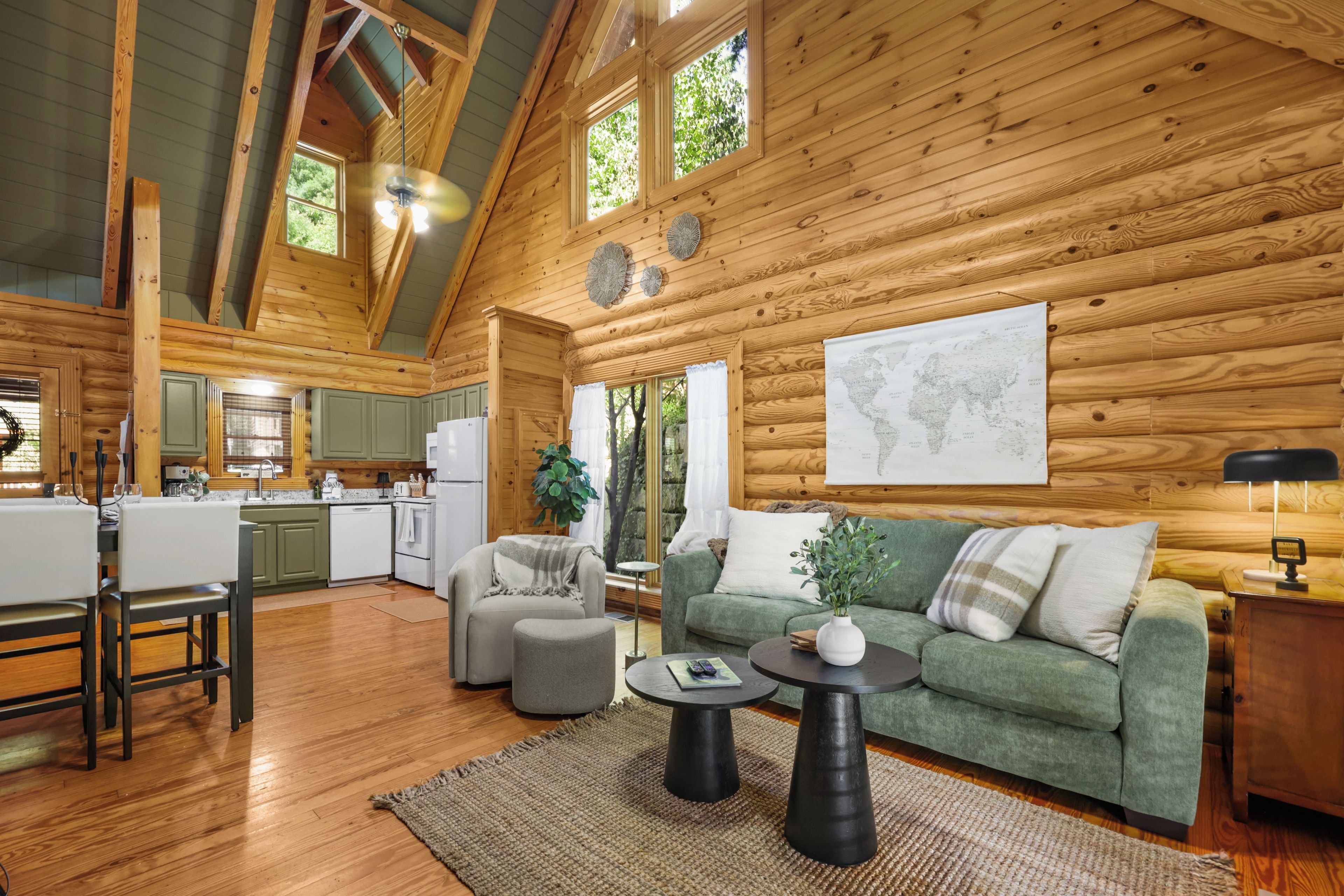 A spacious log cabin interior with a dining area, kitchen, and living room.