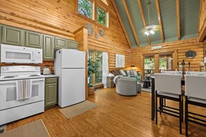 Ein Blockhaus-Interieur mit Küche, Essbereich und Wohnzimmer.