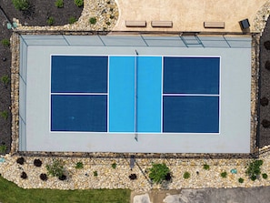 An aerial view of a tennis court with surrounding landscaping and seating. - Private Indoor Pool | Arcade Loft & Hot Tub (Sevierville)