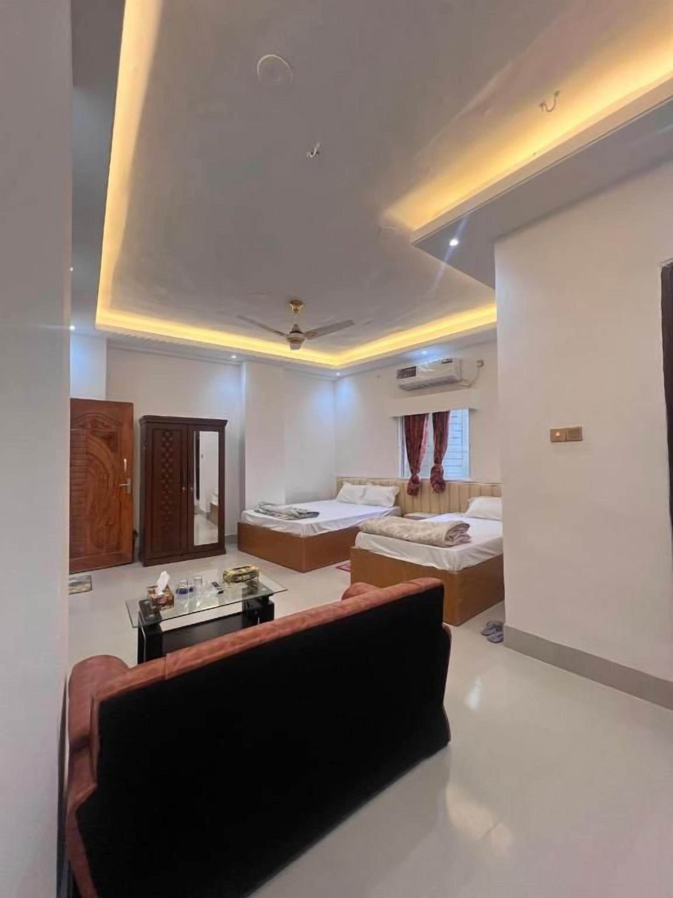 A modern bedroom with a bed, a sofa, a desk, and a wardrobe.