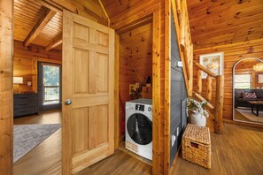 A wooden interior with a washing machine, a door, and a staircase. - Sleeps 6, Family Cabin, Hot Tub, Community Pool, Playground, 6 Mi to Dollywood (Pigeon Forge)