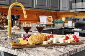 A marble countertop with a cheese board, wine glasses, and a gold faucet. - Sleeps 6, Family Cabin, Hot Tub, Community Pool, Playground, 6 Mi to Dollywood (Pigeon Forge)