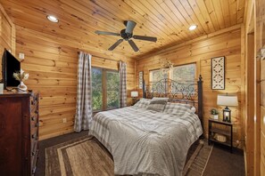 Warm rustic cabin bedroom with king bed and wood-paneled charm - Sleeps 10, Dog Friendly, Hot Tub, Arcade, Pool Table, 2.5 Mi to Gatlinburg (Gatlinburg)