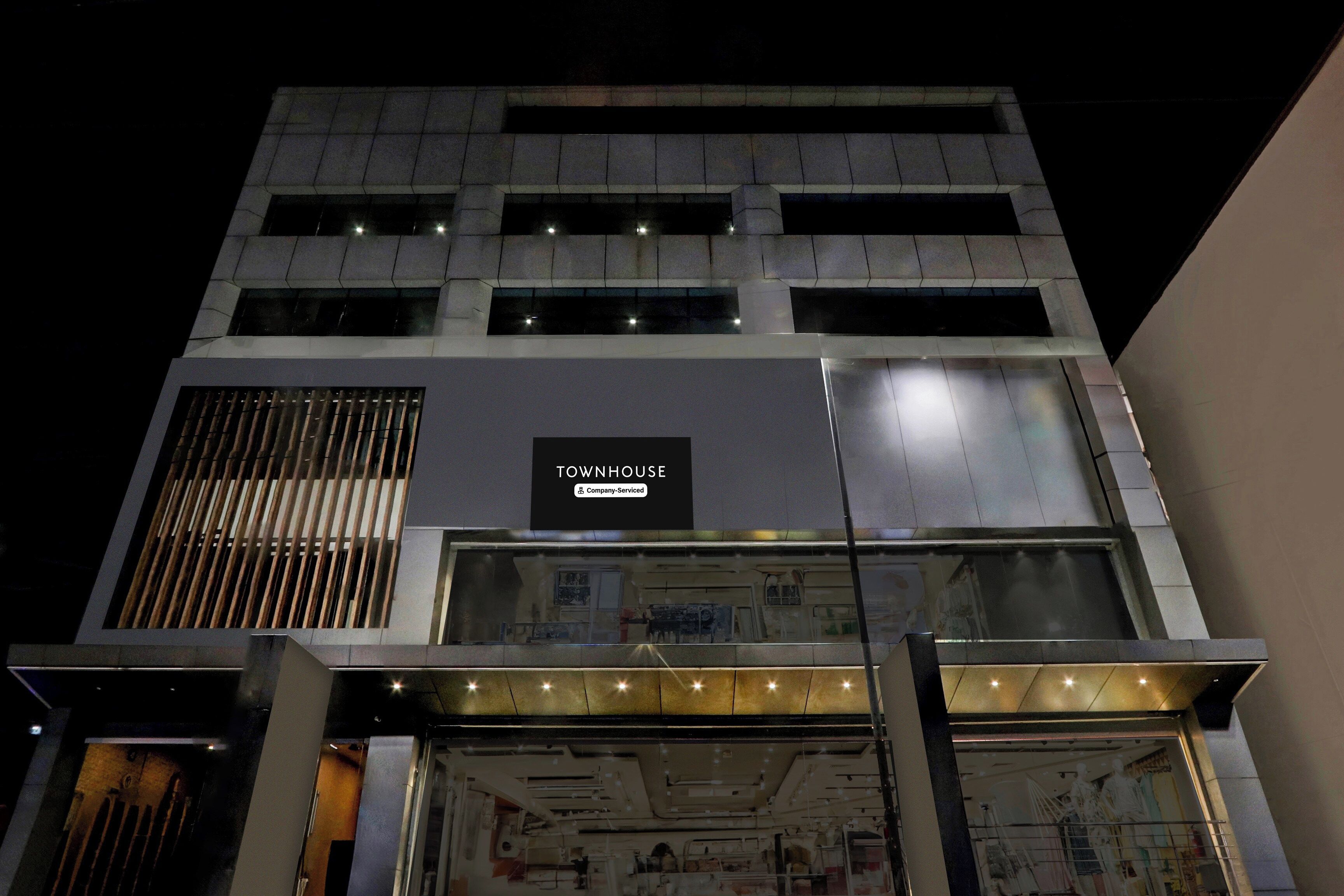 Un edificio de varios pisos con un letrero que dice 'TOWNHOUSE'.