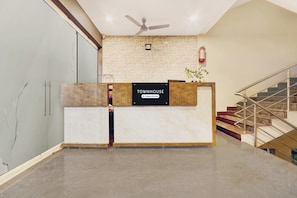 A reception desk with a sign that reads 'TOWNHOUSE Company Serviced.' - Townhouse Daba Garden Road (Visakhapatnam)