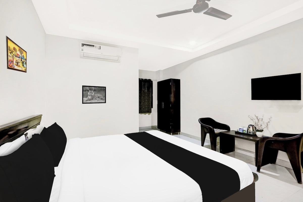 A modern bedroom with a bed, a desk, a chair, a wardrobe, and a ceiling fan.