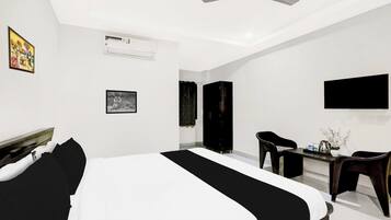 A modern bedroom with a bed, a desk, a chair, a wardrobe, and a ceiling fan.