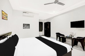 A modern bedroom with a bed, a desk, a chair, a wardrobe, and a ceiling fan. - Townhouse Daba Garden Road (Visakhapatnam)