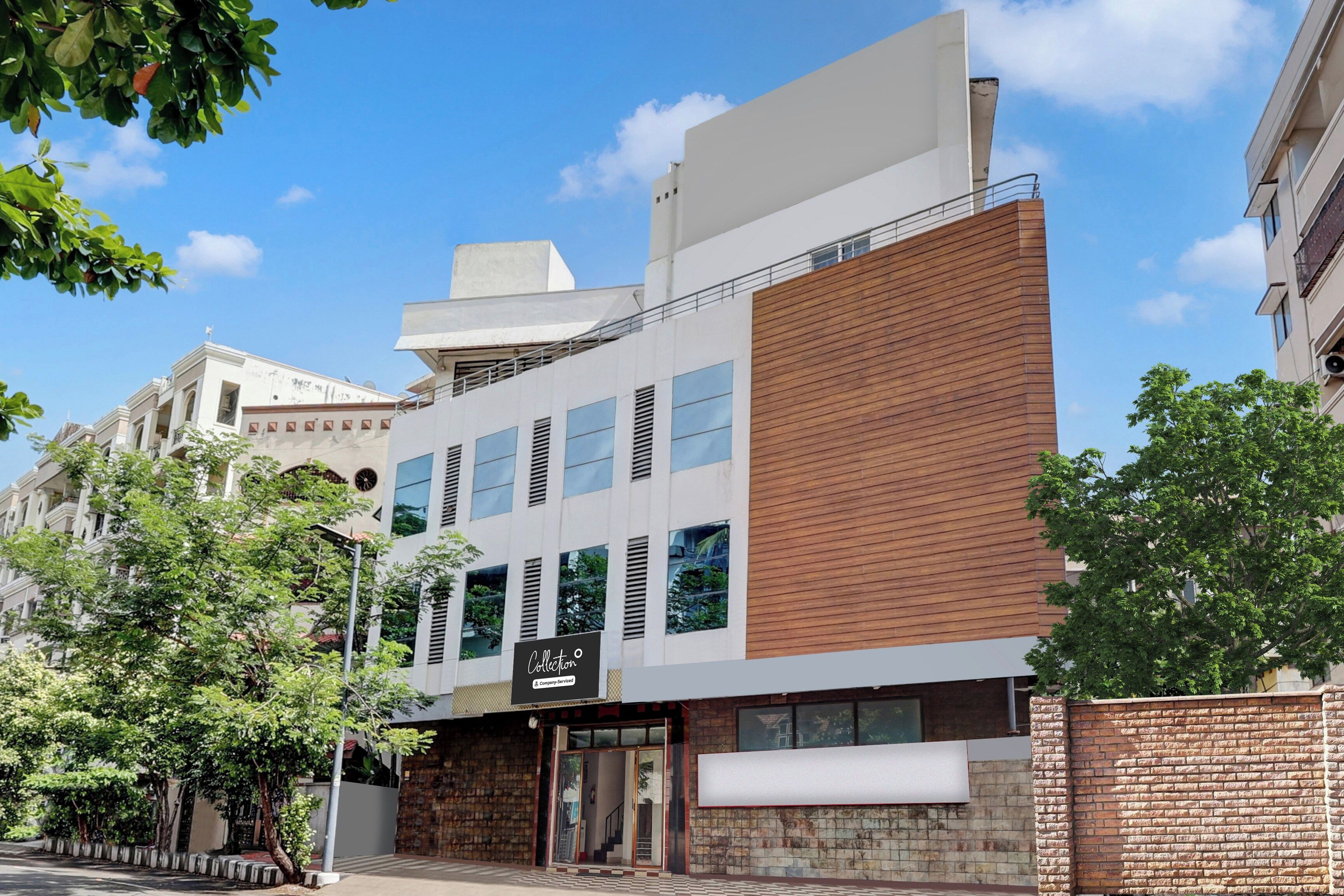 A modern building with a mix of brick and white facade, large windows, and a visible entrance.