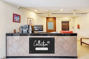 A reception desk with a sign indicating it's a company-serviced collection point. - Super OYO Collection O jagadamba (Visakhapatnam)