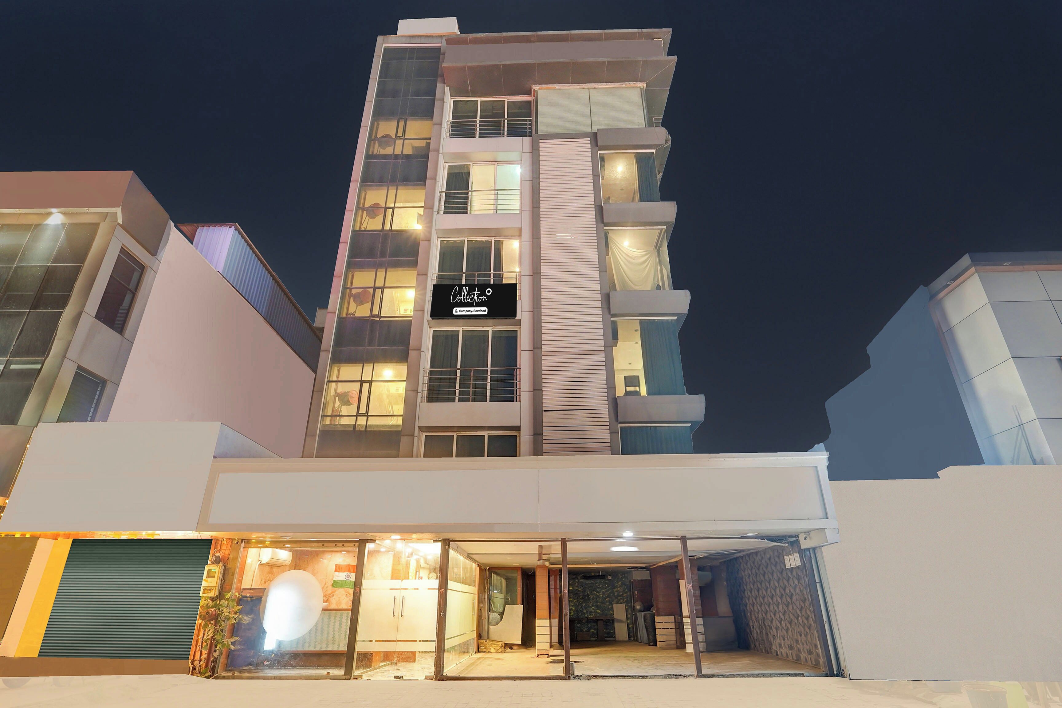 A multi-story hotel with a prominent 'Collection' sign, large windows, and a ground-level entrance with a glass door.