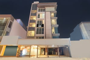 Un hotel de varios pisos con un llamativo letrero que dice 'Collection', ventanas amplias y una entrada principal a nivel de calle con puerta de vidrio.