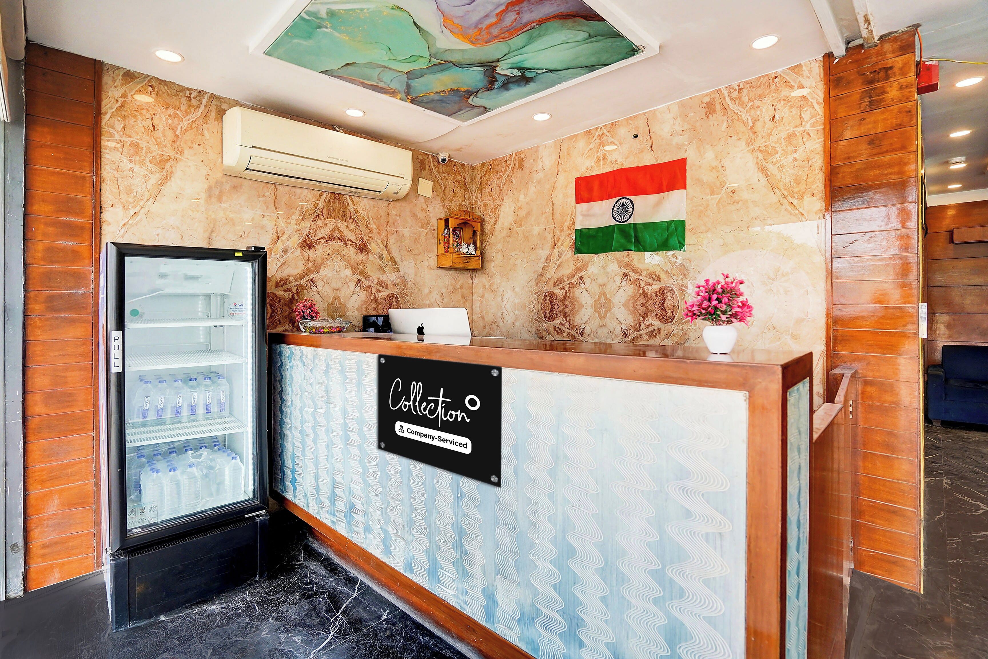 A reception area with a marble wall, a flag, a refrigerator, and a sign indicating the area is company-serviced.