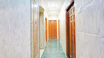 Un pasillo con paredes de mármol y suelo de mármol verde, que conduce a una puerta de madera.