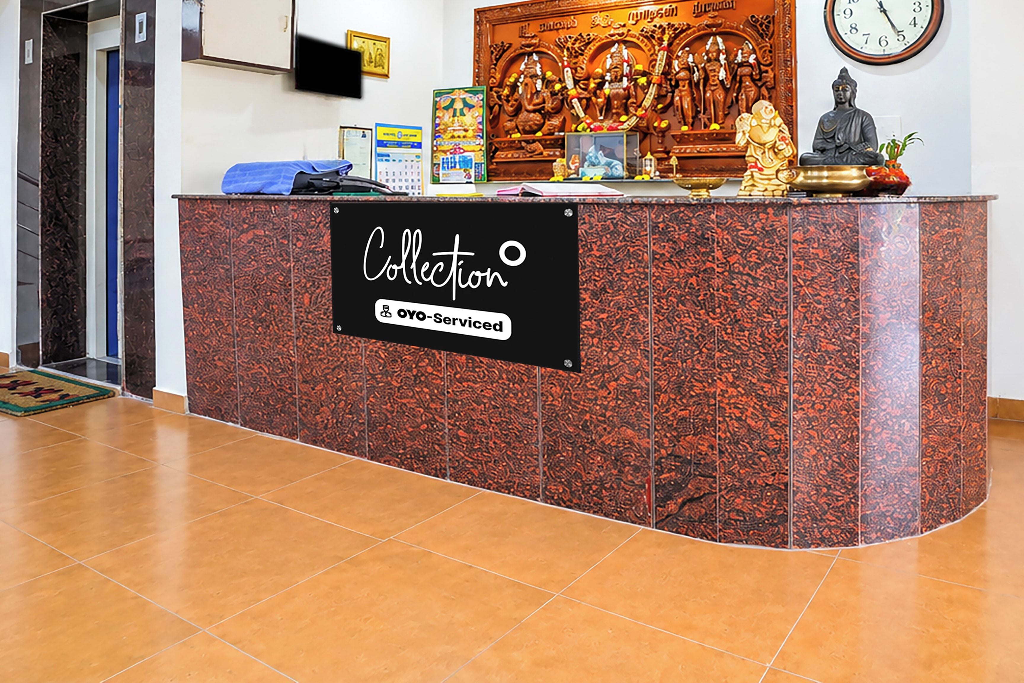 A reception desk with a sign that reads 'Collection oyo-serviced' and a clock on the wall.