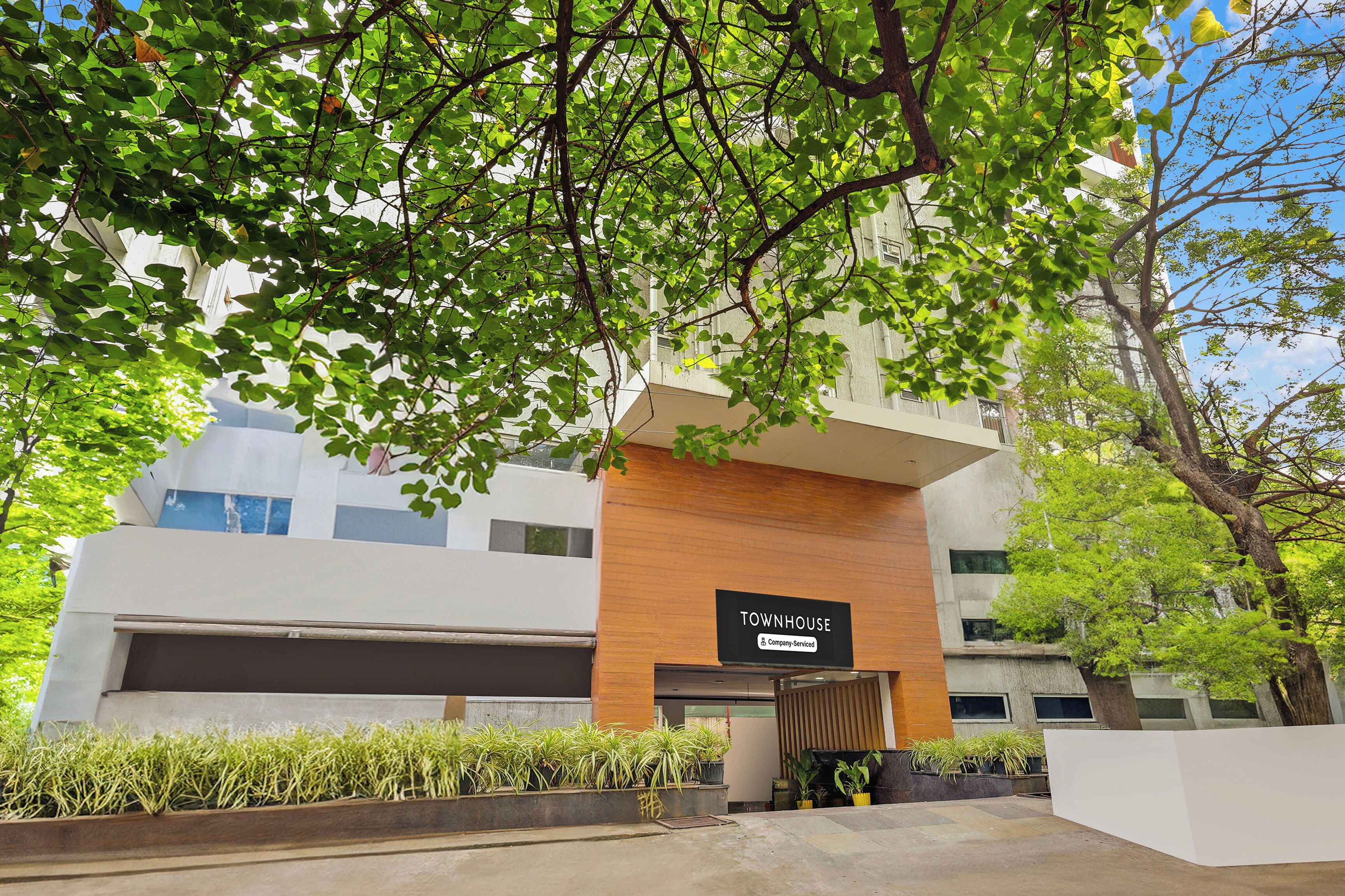 A modern building with a sign reading 'TOWNHOUSE' and a company-serviced symbol.