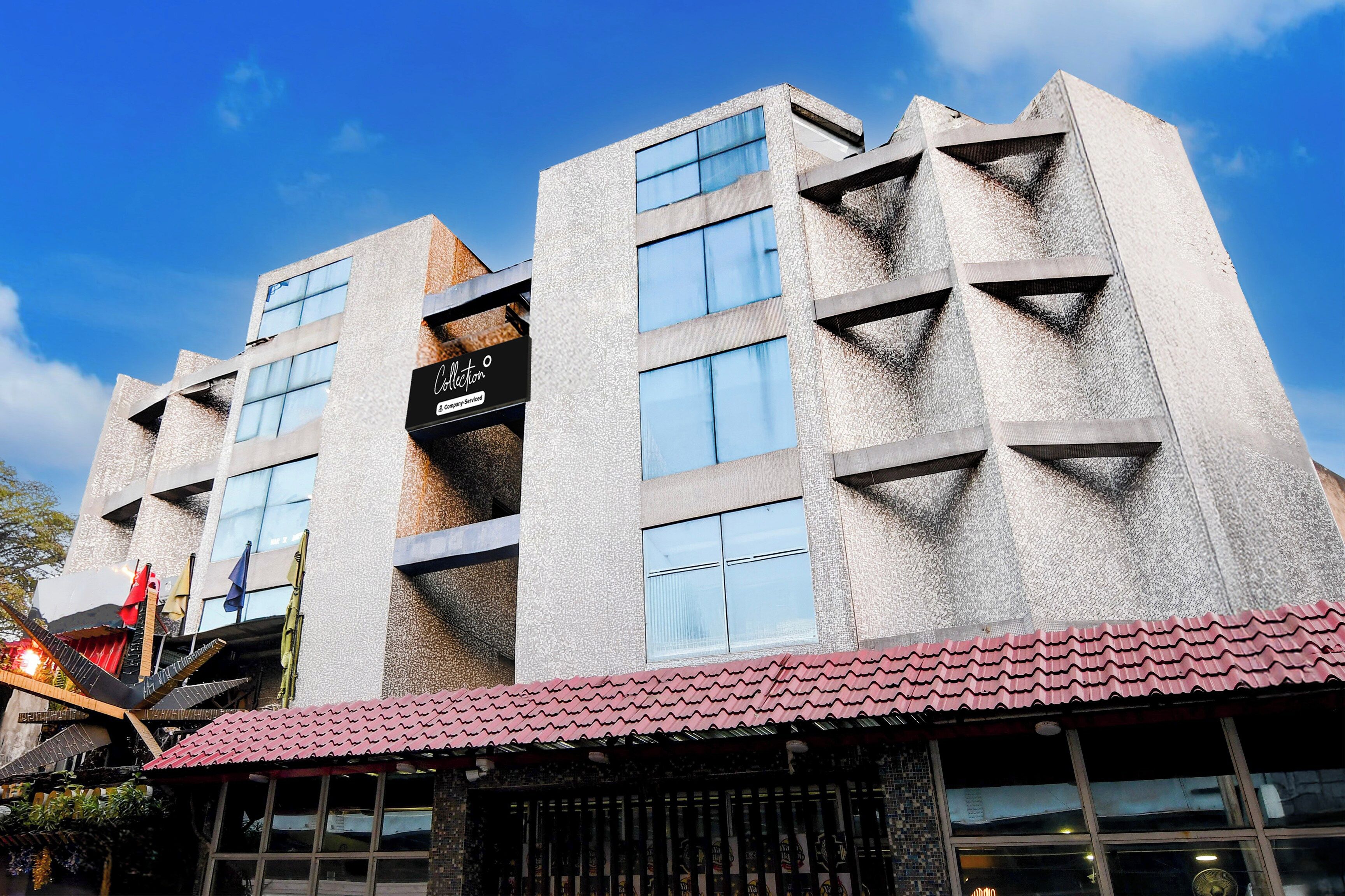A multi-story building with a modern architectural design, featuring large windows and a textured facade.