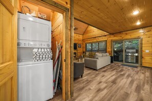 Ein Holzblockhaus-Interieur mit Küchenbereich, Essplatz und Wohnzimmer.