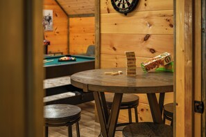 Ein Holzinterieur mit Dartscheibe, Billardtisch und Jenga-Turm.