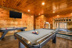A pool table with balls, a foosball table, and a television mounted on the wall. - Sleeps 14, Home Theater, Game Room, Hot Tub, Mountain Views (Gatlinburg)