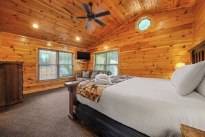 A wooden-paneled room with a bed, a ceiling fan, and two windows with blinds. - Sleeps 14, Home Theater, Game Room, Hot Tub, Mountain Views (Gatlinburg)