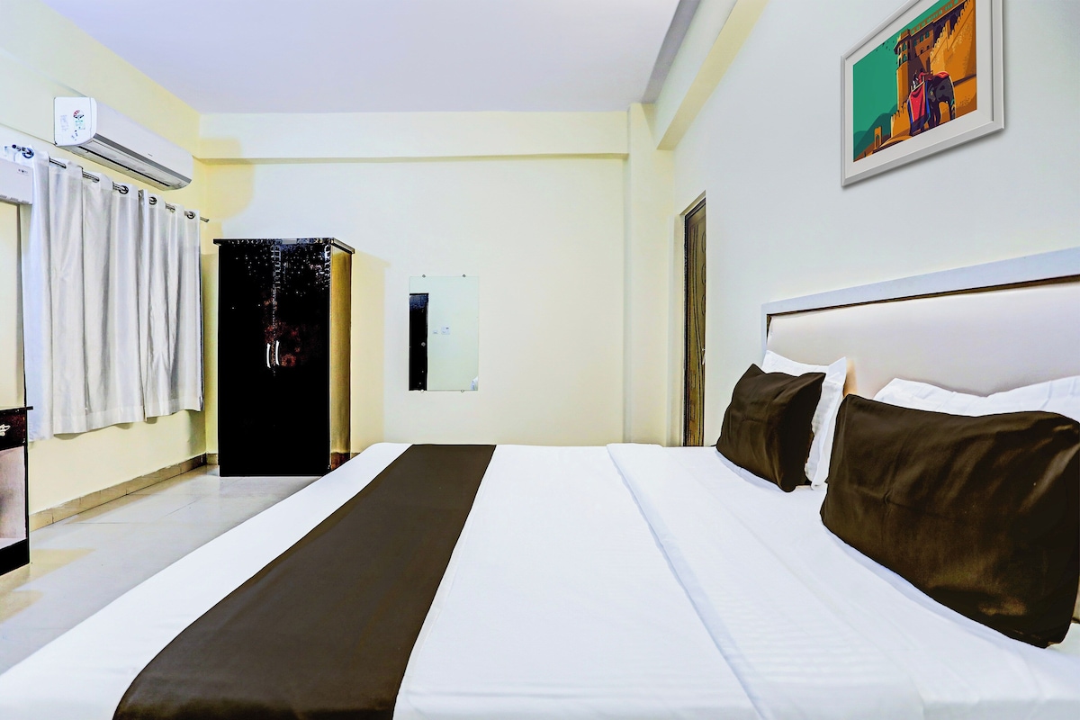 Una habitación de hotel con una cama grande, un armario, un equipo de aire acondicionado y un cuadro en la pared.