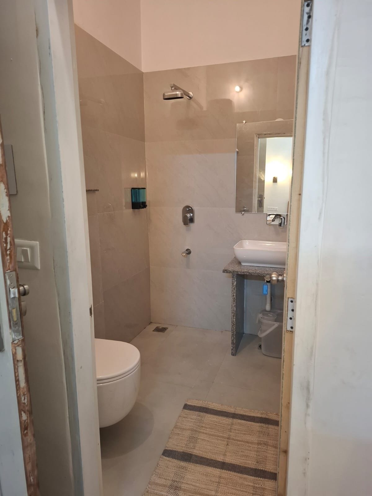 Een badkamer met toilet, wastafel, douche en spiegel.
