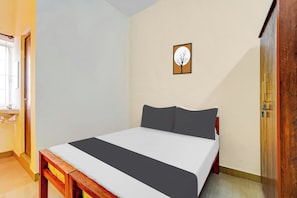 Un dormitorio con cama, cabecera de madera, ventana y puerta.