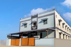 A modern hotel with a flat roof, large windows, and a sign indicating it is company-serviced.